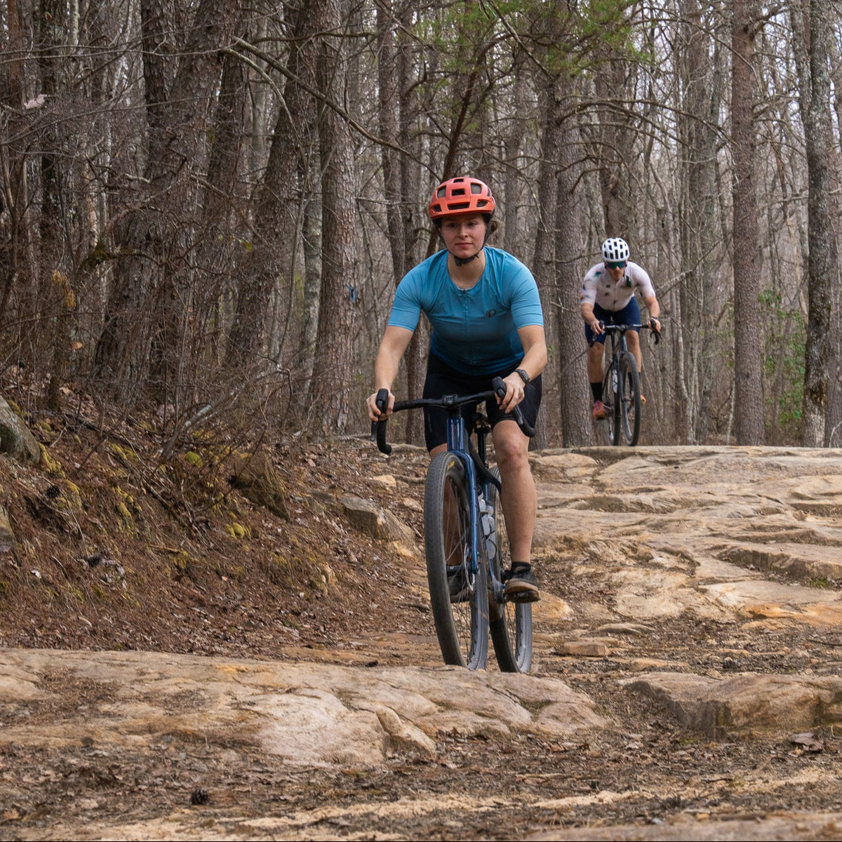 Two mountain bikers on a rocky trail in a forest
