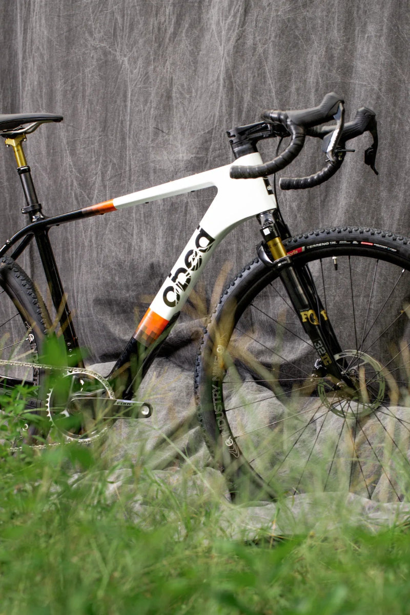OBED MMR leaning against a textured wall with grass in the foreground