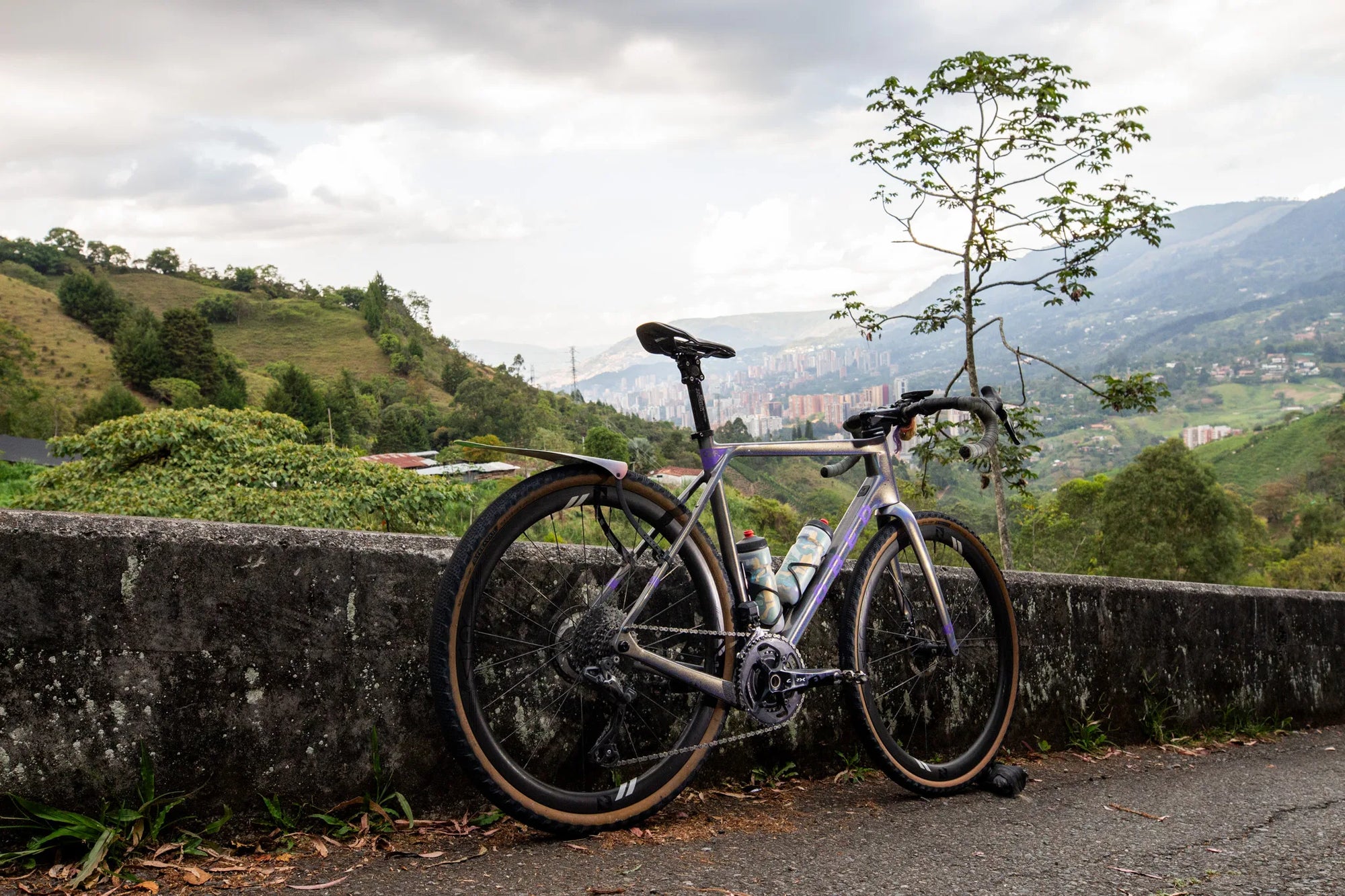 An OBED GVR leaning against a stone wall with a scenic background of hills and trees in Columbia.