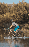 Man riding Obed Boundary gravel bike through water